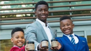 Three of the founders of the candle company posing with products